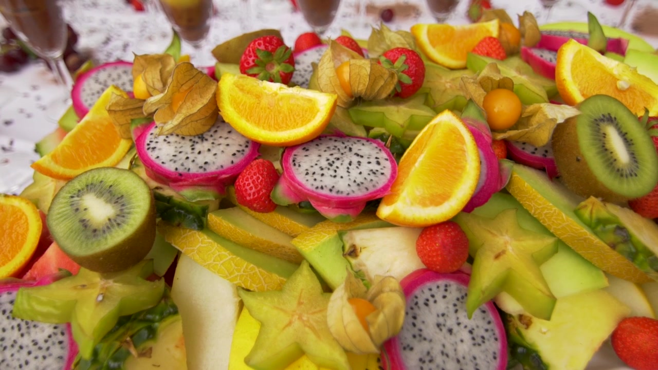Fargerik blanding av ferske frukter. Appelsin, jordbær, kiwi, dragefrukt, melon og mer