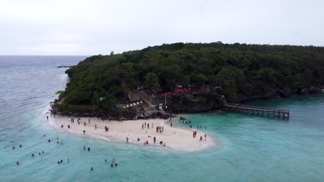 perspectiva aérea de la playa de arena blanca de la isla de sumilon, con turistas nadando en aguas tropicales claras, una pequeña isla turística en mar abierto cerca de oslob en cebu filipinas