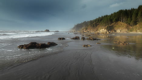 beautiful low flying drone camera angle above pacific ocean coast line on the wild beach in washington state, usa