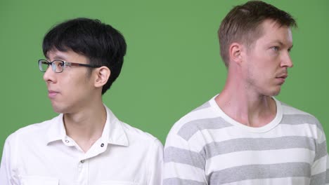 두 명의 젊은 다민족 사업가들이 서로 반대 방향을 바라보고 있습니다.