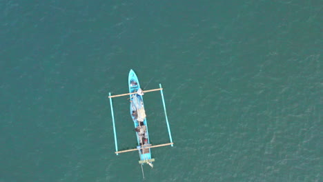 pasando por un colorido barco local de cruceros anclado frente a la costa de bali, vista aérea de dios