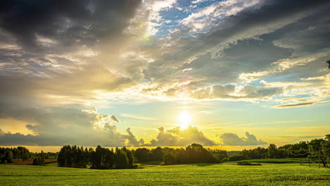 Timelapse-shot-of-sun-rising-over-green-grasslands-with-dark-clouds-passing-by-at-dawn