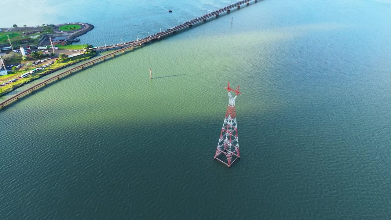 Aerial Wide Establishing View of High Voltage Transmission Tower in Paraná River near San Roque González Bridge