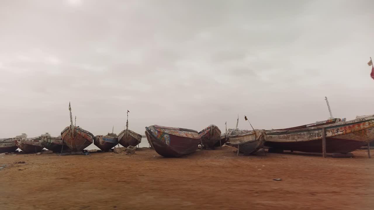 coloridos barcos de pesca parados en la arena en la costa de senegal