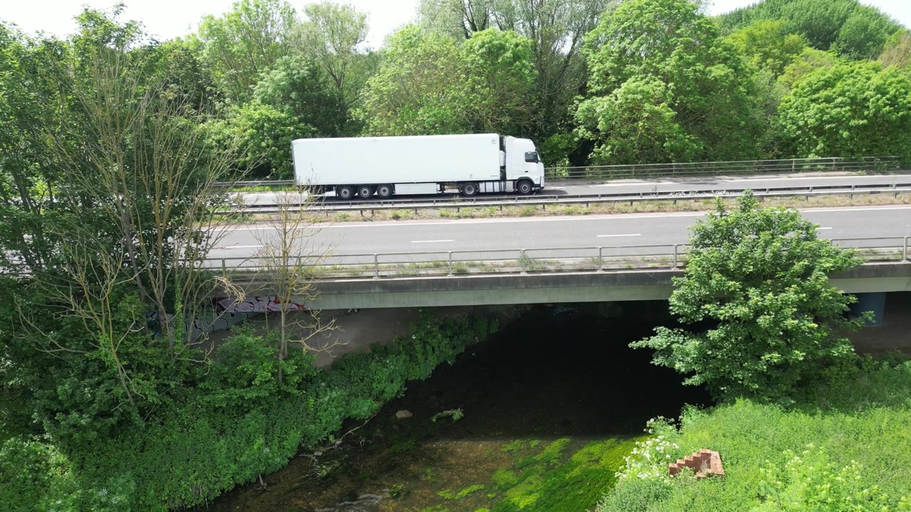 Aerial View of A2 Motorway Concrete Bridge Over Green Stream in Lush Woodland Hambrook Kent UK
