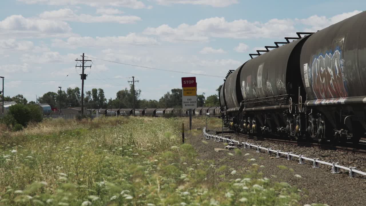 A freight train moves slowly through a rural area near Narrabri West, New South Wales, Australia.