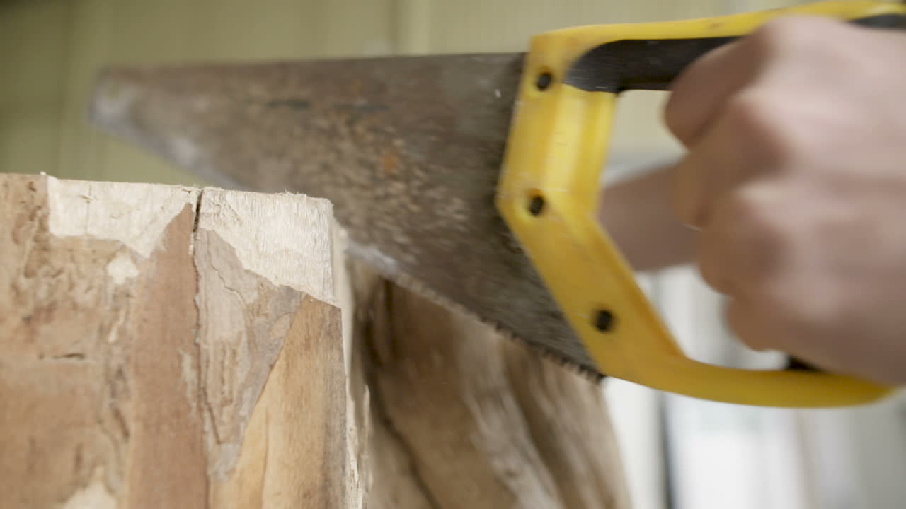 carpintero cortando madera con serrucho en taller 5