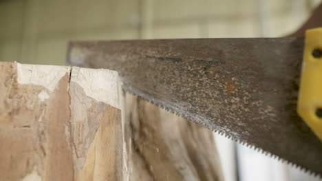 carpenter cutting wood with handsaw in workshop 5