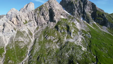 beautiful-aerial-landscape-of-green-mountain-face-in-the-dolomites-of-Italian-Alps-on-a-sunny-summer-day-with-blue-skies