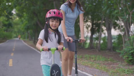 mother and daughter learning to scooter