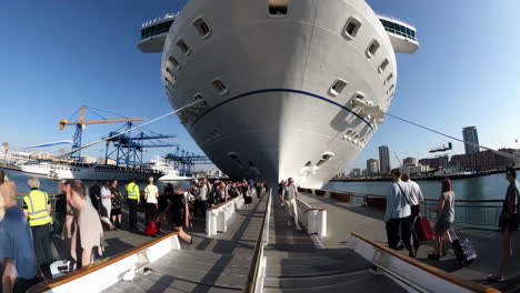 large cruise ship with passengers boarding at a busy port