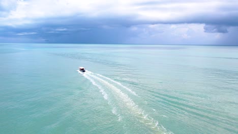 aerial tracking shot tracking of a speedboat travelling through the tropical ocean