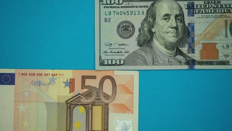 us dollars and euro banknotes on blue