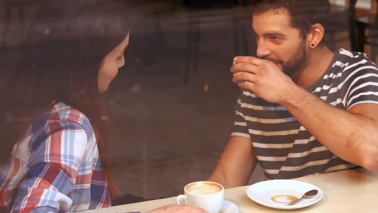 pareja feliz interactuando entre sí mientras toman café