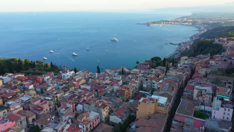 flying over a beautiful sicilian town with small colorful houses near blue mediterranean sea