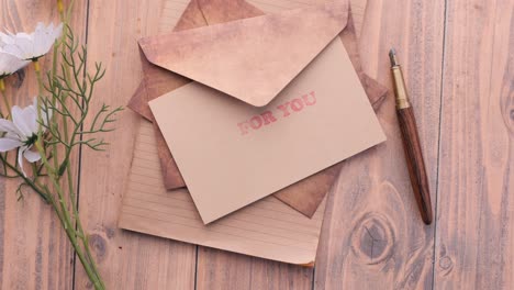 sobre, papel vacío y pluma estilográfica en la mesa