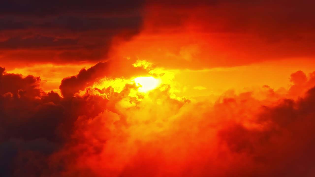 Arte aéreo de un ardiente atardecer rojo con rayos de sol atravesando nubes oscuras