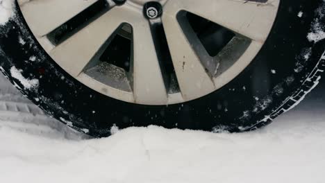 car tyre moving on snow during snowfall