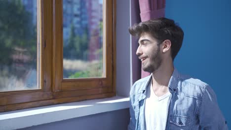 el hombre frente a la ventana, respirando profundamente y cerrando los ojos.