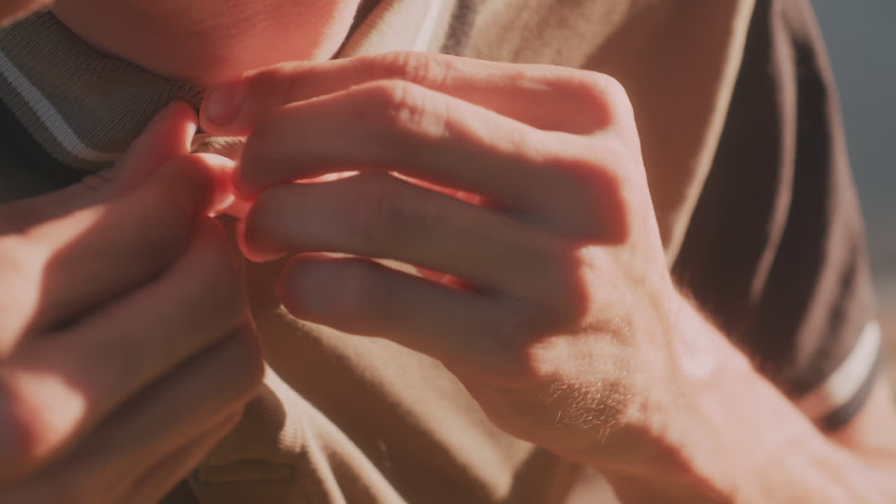 White Man CloseUp Buttoning Shirt Collar With Intense Finger Movements, Tight Framing On Hands And Face Highlights Texture Of Fabric, Concentrated Motion Suggests Compulsive Behavior And Anxiety
