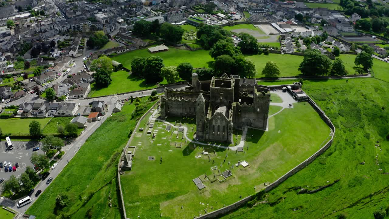 Orbiting drone shot of Rock of Cashel overlooking Ireland's countryside.