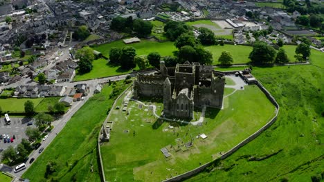orbiting drone shot of rock of cashel overlooking ireland's countryside.