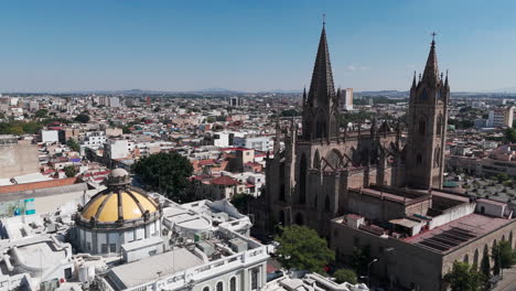 aerial shot of the expiatorio parish and the museo de las artes in guadalajara, jalisco, mexico, with the traffic of the vallarta avenue