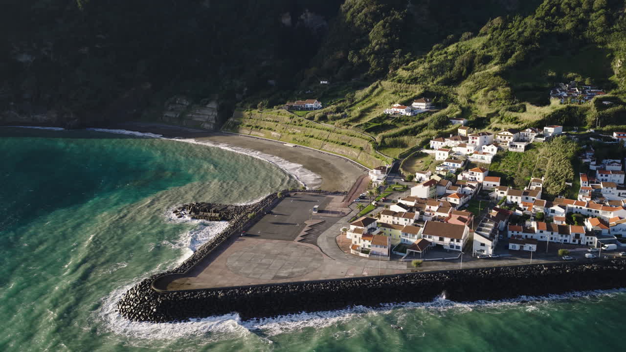 Vista Aerea di un Pittoresco Villaggio Costiero con Spiaggia e Porto