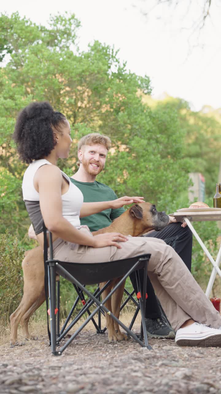 Couple enjoying a picnic with their dog outdoors