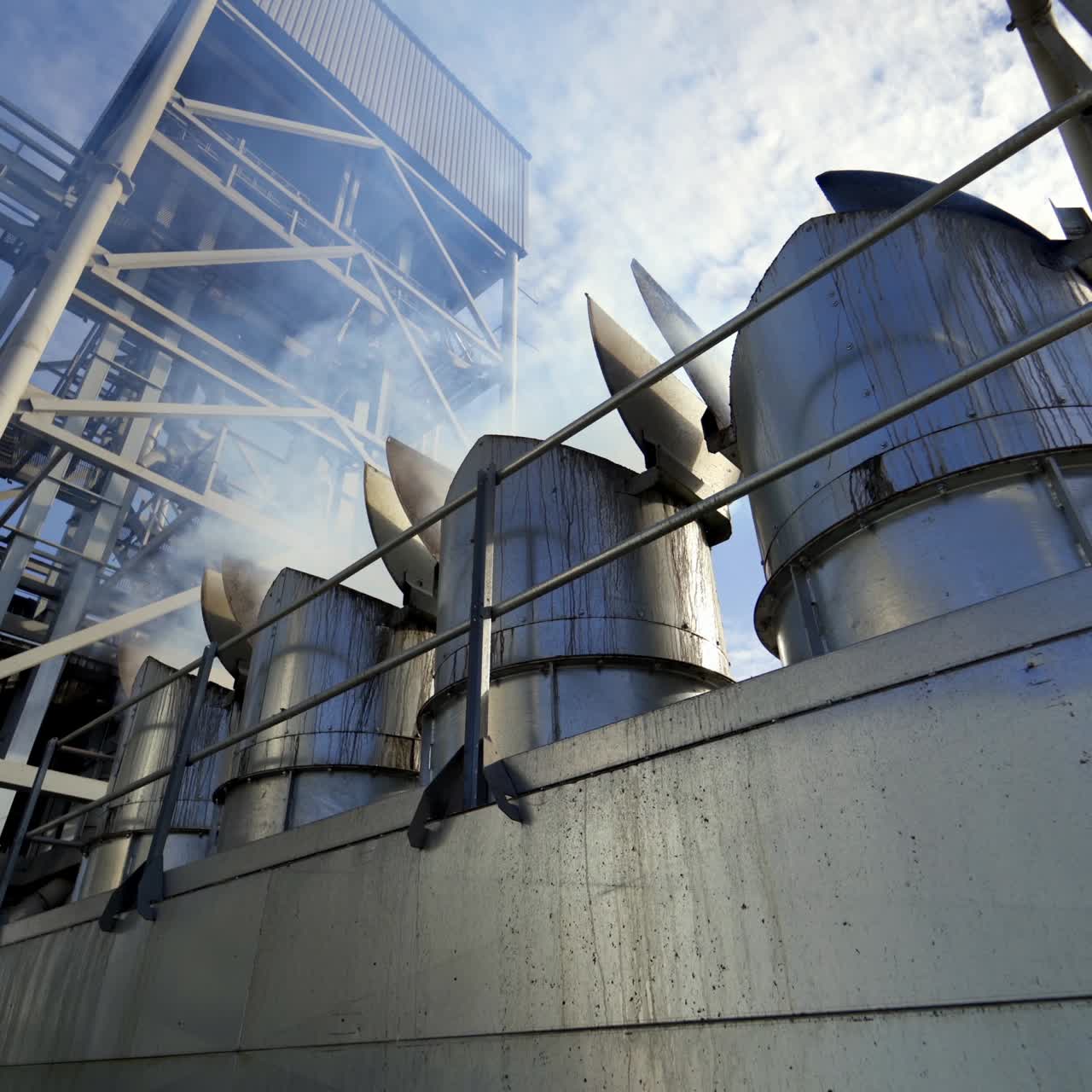 Harmful vapor from industry. Modern building for agribusiness on sky background. White smoke from industrial plant during grain processing. Close-up.