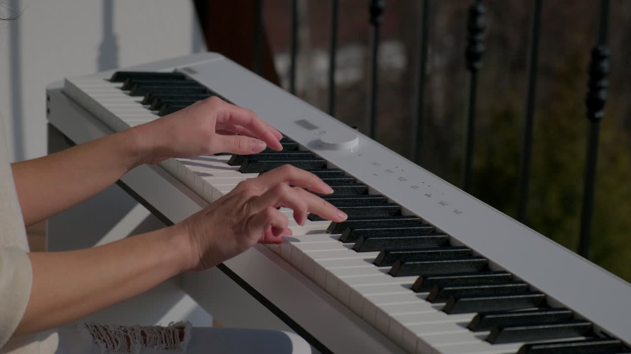 mujer tocando el piano en un balcón