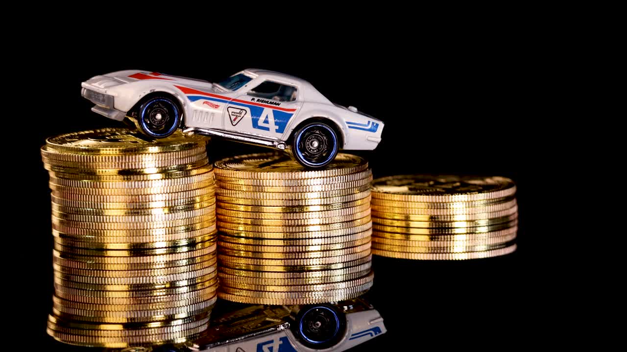 Die-cast toy car rotates atop shiny gold coin stacks, dramatic lighting, black reflective background