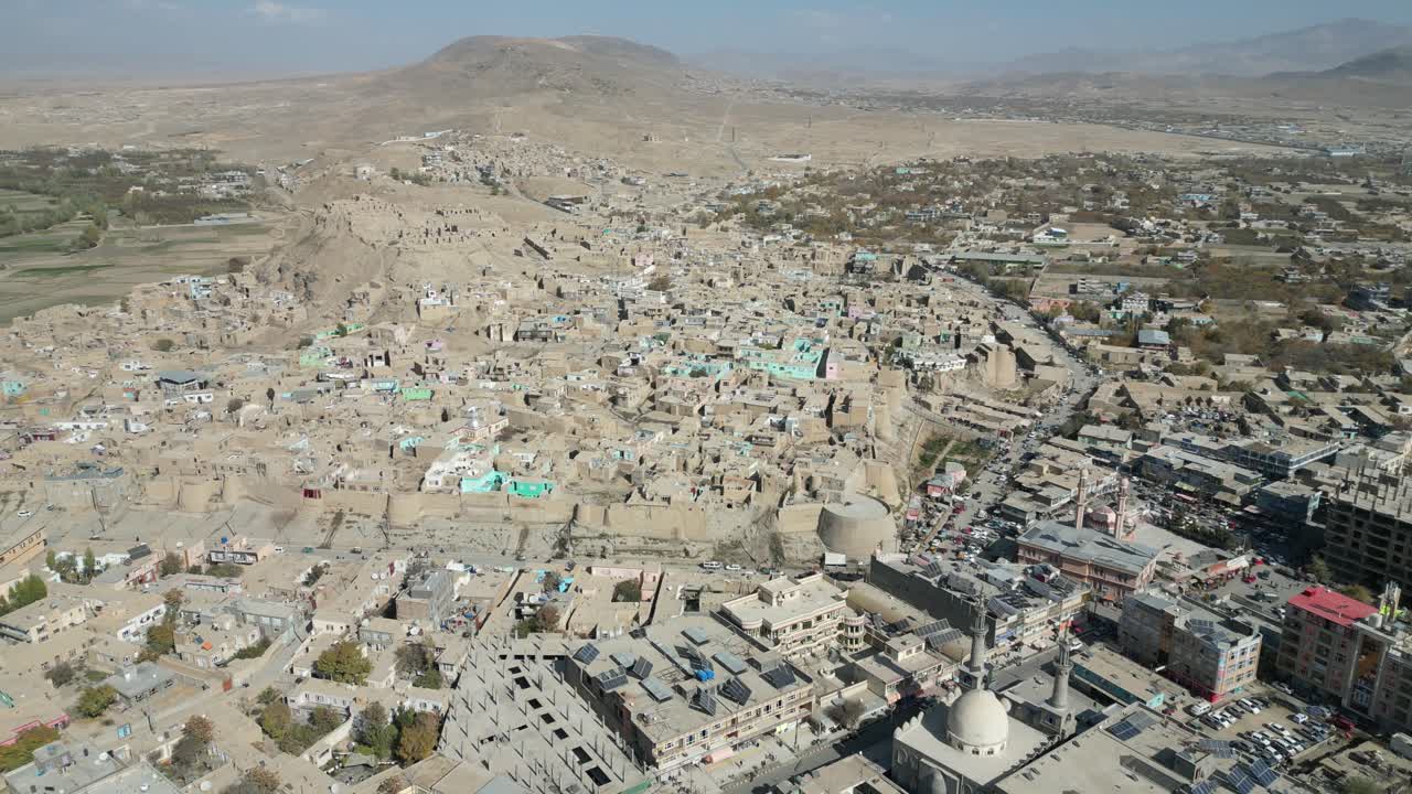 Aerial View Of Ghazni With Historic Medieval Citadel Fortress, City Buildings And Homes In Afghanistan. - pullback shot