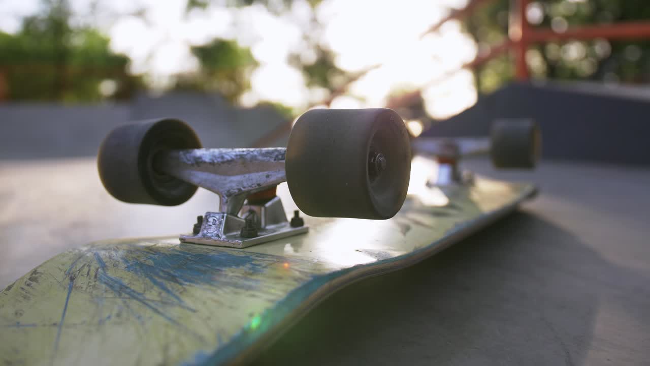toma de primer plano de la patineta en el suelo en los rayos del sol