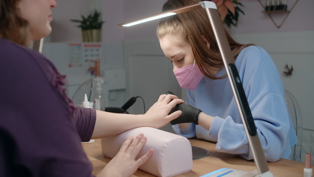 una mujer haciendo una manicura en un salón de uñas.