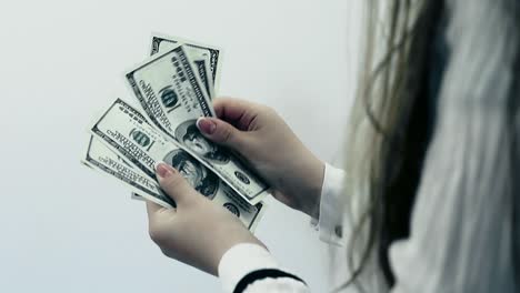 European-long-haired-brunette-girl-counts-US-100-dollar-bills