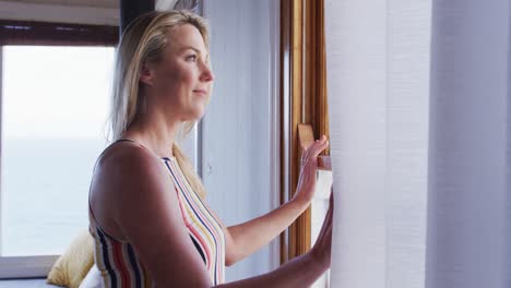 portrait of happy caucasian mature woman looking through the window
