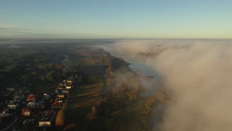 Drone-aerial-view-of-fog-over-the-Nemunas-river-during-sunrise-in-early-autumn-morning-in-Kaunas-county,-Lithuania