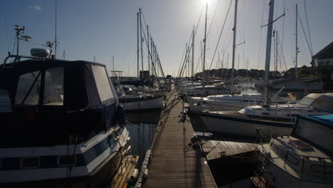 shot looking down a pontoon full of sailboats at hythe marinapontoon, hythe marina village, houses, boats, sailboats, locks, solent, sea, hythe, marina, fhv23, uk, autumn