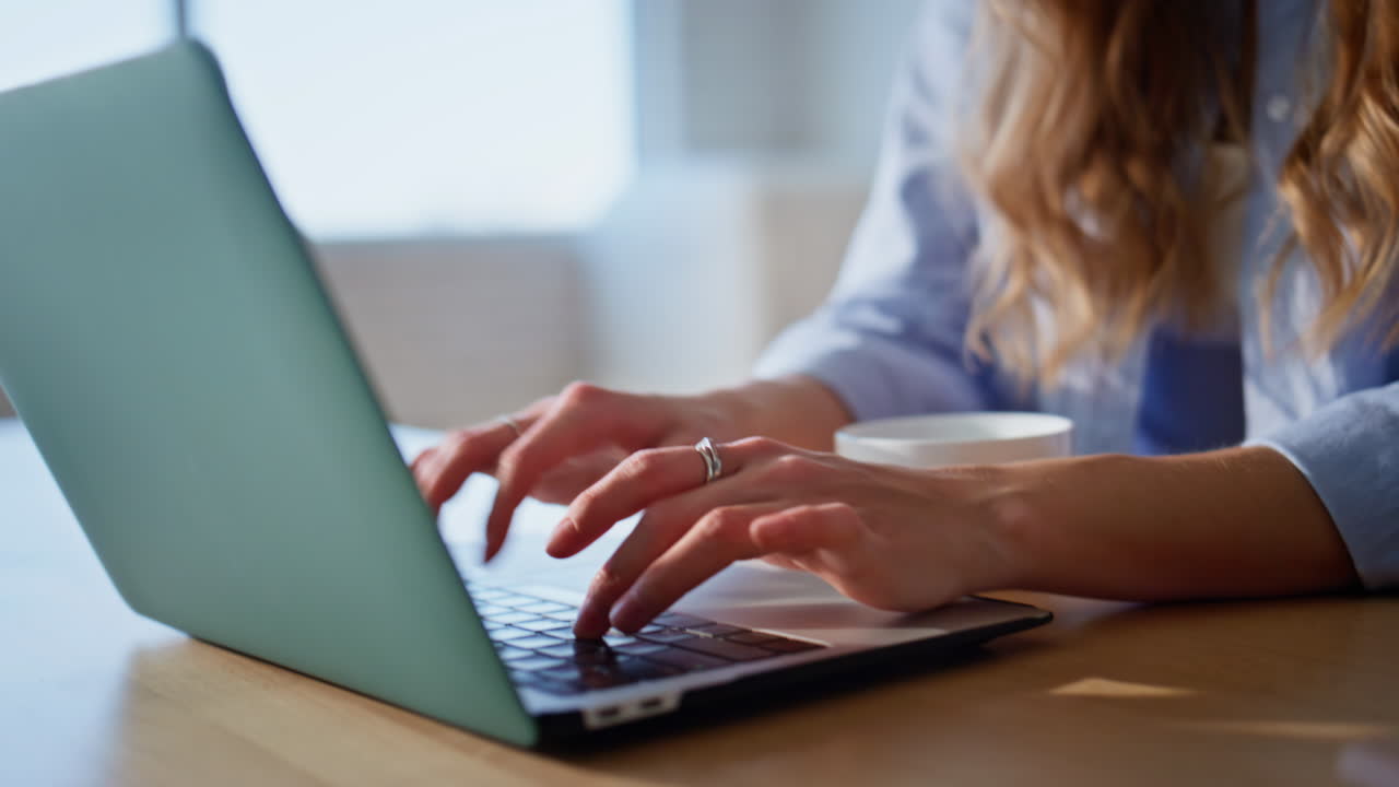 Morning woman drinking coffee at home kitchen closeup. Woman typing keyboard