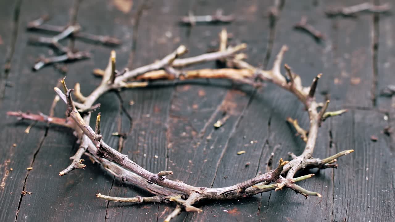A rustic wreath of intertwined twigs on a weathered wooden surface, evoking a the sense