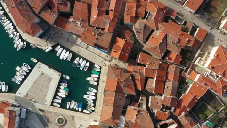 toma aérea que desciende hacia un puerto deportivo en la isla de cres, croacia en un día brillante