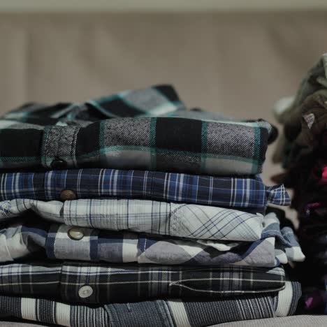 women's hands put men's shirts in a neat pile 1