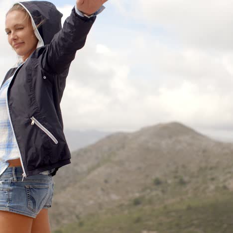 mujer deportiva de pie en la cima de la roca