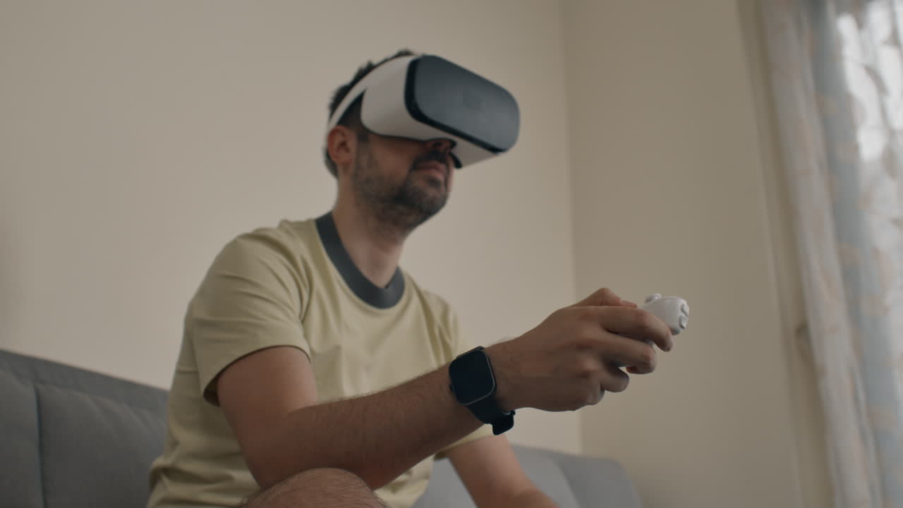 Uomo concentrato nel gaming VR con espressione focalizzata, che usa il controller per interagire.