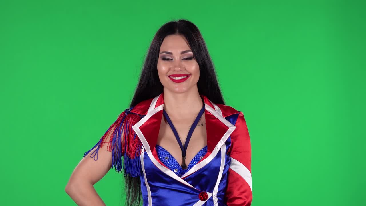 빨간색, 파란색, 색의 매혹적인 의상을 입은 아름다운 여성의 초상화는 라인스톤과 함께 똑바로 쳐다보고 미소 짓고 있습니다. 녹색 화면