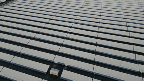 solar panels of solar power plant covered in snow and ice, diagonal lines, drone shot, slow movement forward