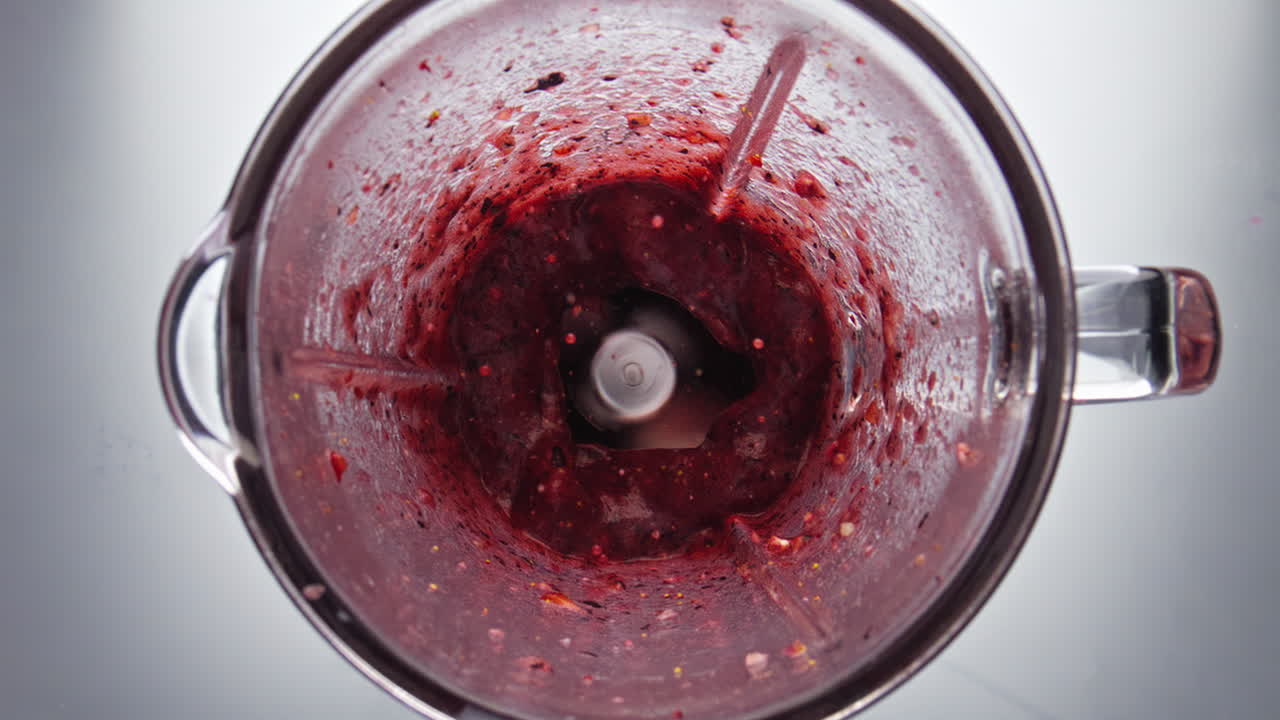 свежий ягодный коктейль вращается внутри блендера в супер медленном движении.