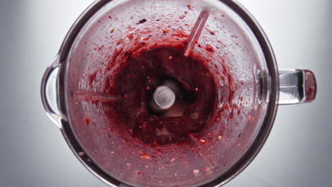 fresh berry smoothie swirling inside blender in super slow motion close up.