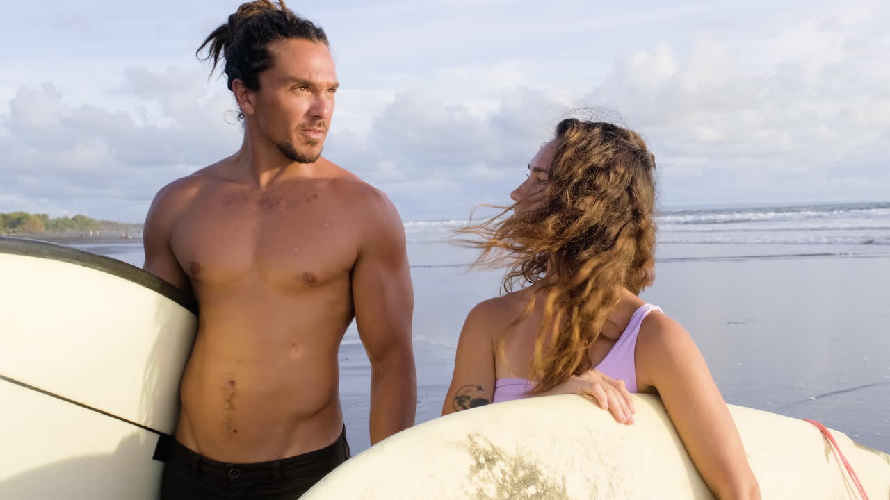 pareja joven con tablas de surf